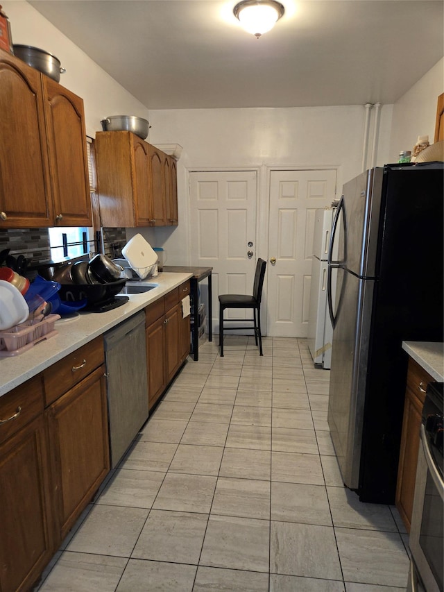 731 E 218th St, Bronx, NY 10467 - kitchen with stainless steel appliances, light countertops, light tile patterned floors, and backsplash