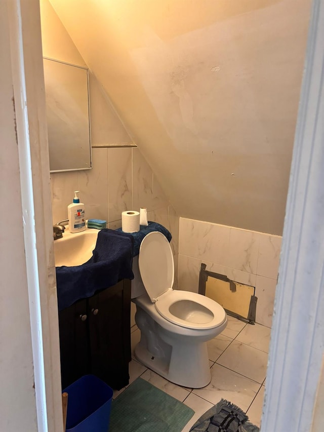 731 E 218th St, Bronx, NY 10467 - bathroom with marble look tiles, vanity, and lofted ceiling