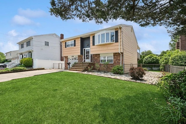 473 S 15th St, Lindenhurst, NY 11757 - bi-level home with concrete driveway, brick siding, and an attached garage