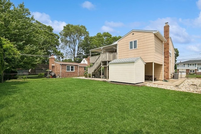 473 S 15th St, Lindenhurst, NY 11757 - back of property with stairs, a chimney, a storage unit, and brick siding