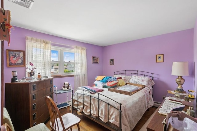 473 S 15th St, Lindenhurst, NY 11757 - bedroom featuring wood finished floors and a baseboard heating unit