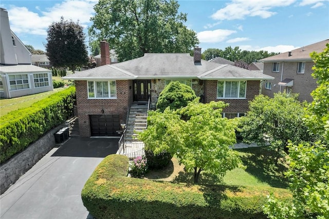 156 Valentine St, Yonkers, NY 10704 - view of front facade with stairway, brick siding, a chimney, and asphalt driveway