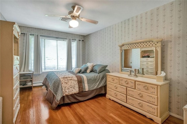 156 Valentine St, Yonkers, NY 10704 - bedroom with wood finished floors, a baseboard radiator, wallpapered walls, and a ceiling fan