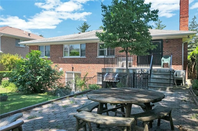 156 Valentine St, Yonkers, NY 10704 - back of house featuring brick siding, a chimney, outdoor dining area, and a patio