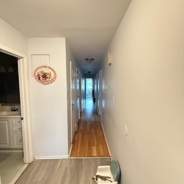 149-45 83rd St, Howard Beach, NY 11414 - corridor with a sink, wood finished floors, and baseboards