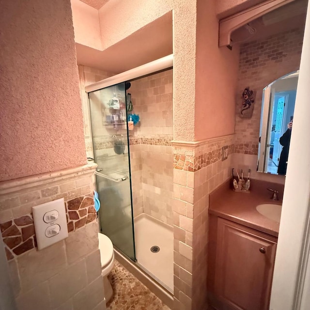 149-45 83rd St, Howard Beach, NY 11414 - full bath with tile walls, a shower stall, vanity, toilet, and wainscoting