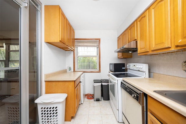 124 Herzl St, Brooklyn, NY 11212 - kitchen featuring under cabinet range hood, white appliances, light countertops, tasteful backsplash, and light tile patterned floors