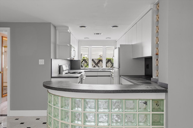 162-25 89th St, Howard Beach, NY 11414 - kitchen featuring white appliances, dark countertops, and white cabinetry