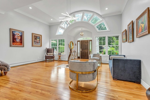 21 Buttonwood Dr, Dix Hills, NY 11746 - living area featuring baseboard heating, light wood-style flooring, ornamental molding, high vaulted ceiling, and a chandelier