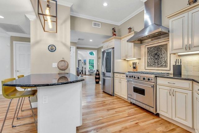 21 Buttonwood Dr, Dix Hills, NY 11746 - kitchen with wall chimney exhaust hood, appliances with stainless steel finishes, cream cabinets, ornamental molding, and a kitchen bar