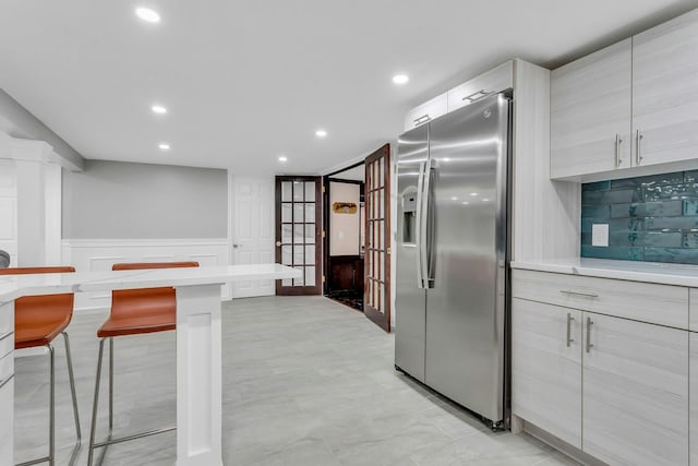 21 Buttonwood Dr, Dix Hills, NY 11746 - kitchen featuring stainless steel fridge, a breakfast bar, light countertops, recessed lighting, and wainscoting