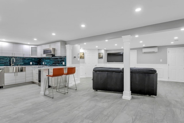 21 Buttonwood Dr, Dix Hills, NY 11746 - kitchen with modern cabinets, a sink, a wall mounted AC, stainless steel appliances, and a decorative wall
