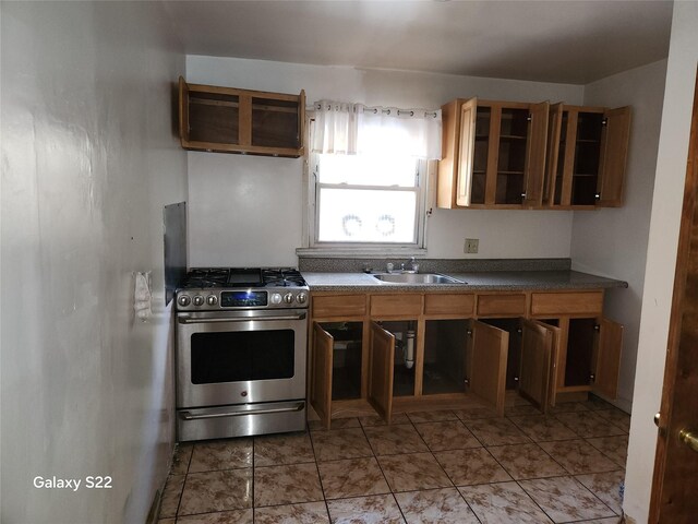 32 Yonkers Ave, Yonkers, NY 10701 - kitchen featuring gas stove, a sink, glass insert cabinets, dark countertops, and brown cabinets