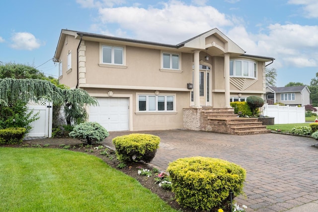27 Suzanne Ln, Bethpage, NY 11714 - bi-level home with stucco siding, decorative driveway, and a garage
