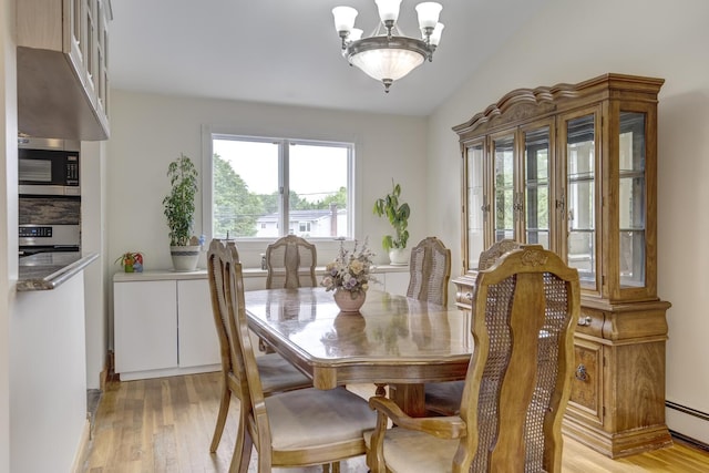 27 Suzanne Ln, Bethpage, NY 11714 - dining area featuring baseboard heating, light wood finished floors, and a chandelier