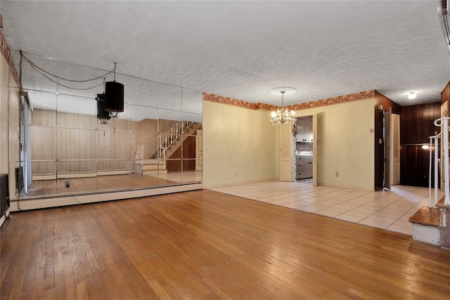 69-14 61st Rd, Middle Village, NY 11379 - unfurnished living room with hardwood / wood-style flooring, a chandelier, and a baseboard radiator