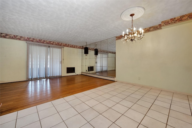 69-14 61st Rd, Middle Village, NY 11379 - unfurnished living room featuring a baseboard radiator, wood finished floors, and a chandelier