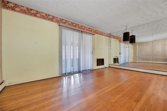 69-14 61st Rd, Middle Village, NY 11379 - unfurnished living room featuring wood finished floors and a baseboard radiator