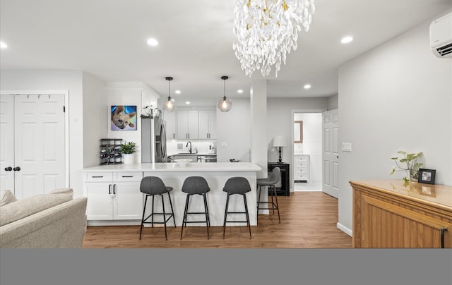 1101 162nd St Unit 6C, Beechhurst, NY 11357 - kitchen featuring stainless steel fridge, a peninsula, a breakfast bar area, white cabinets, and recessed lighting