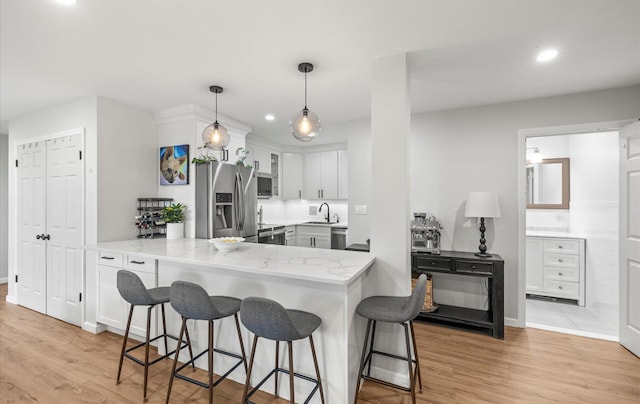 1101 162nd St Unit 6C, Beechhurst, NY 11357 - kitchen with stainless steel appliances, light stone counters, a kitchen breakfast bar, a peninsula, and recessed lighting