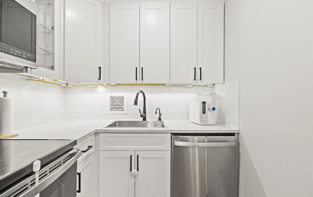 1101 162nd St Unit 6C, Beechhurst, NY 11357 - kitchen with stainless steel appliances, a sink, decorative backsplash, and white cabinetry