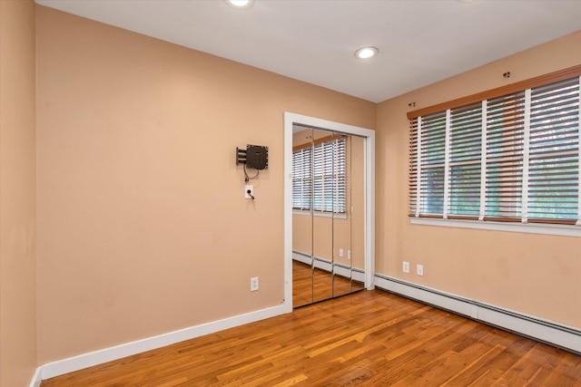517 Birch St, West Hempstead, NY 11552 - empty room with wood finished floors, recessed lighting, and a baseboard heating unit
