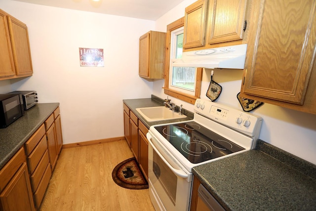 342 Bernas Rd, Cochecton, NY 12726 - kitchen with electric stove, under cabinet range hood, a sink, dark countertops, and light wood finished floors