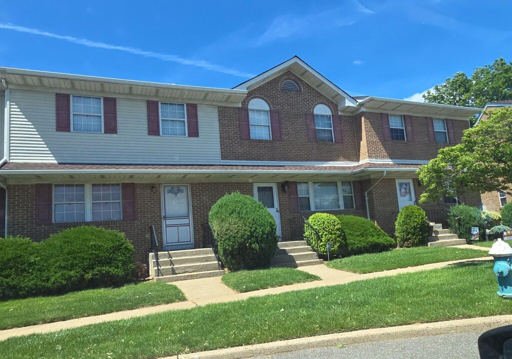 815 Franklin Ave Unit 4, Franklin Square, NY 11010 - townhome / multi-family property with entry steps, brick siding, and a front lawn