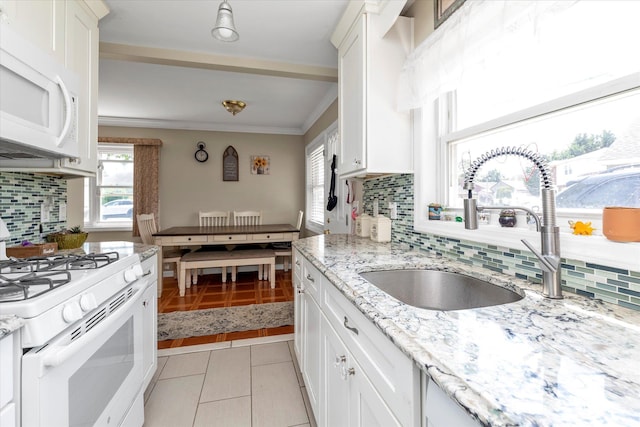 487 Sunnybrook Dr, Oceanside, NY 11572 - kitchen featuring white appliances, a sink, tasteful backsplash, white cabinets, and light tile patterned flooring