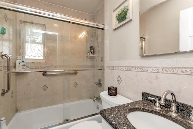 487 Sunnybrook Dr, Oceanside, NY 11572 - bathroom with toilet, bath / shower combo with glass door, vanity, and tile walls