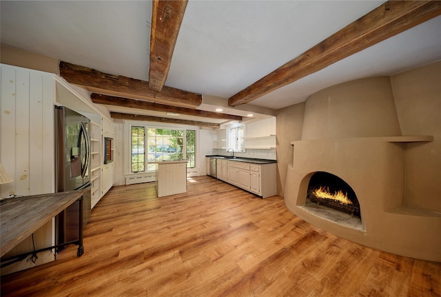 94 Cedar Ave, Poughkeepsie, NY 12603 - kitchen featuring a sink, a large fireplace, light wood-style flooring, beamed ceiling, and dark countertops