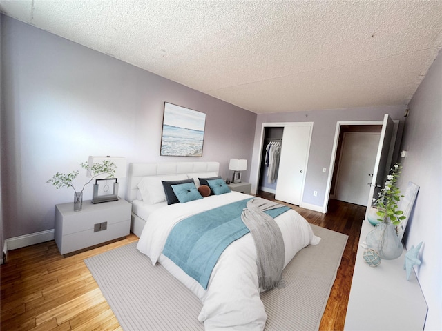 221 Bch 80th St Unit 2J, Rockaway Beach, NY 11693 - bedroom with wood finished floors, a textured ceiling, a closet, and baseboards
