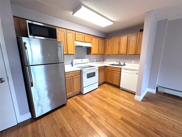221 Bch 80th St Unit 2J, Rockaway Beach, NY 11693 - kitchen with stainless steel appliances, under cabinet range hood, a sink, light countertops, and light wood-style floors