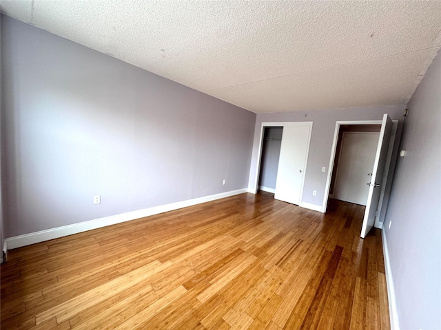 221 Bch 80th St Unit 2J, Rockaway Beach, NY 11693 - unfurnished bedroom featuring wood finished floors, baseboards, a closet, and a textured ceiling