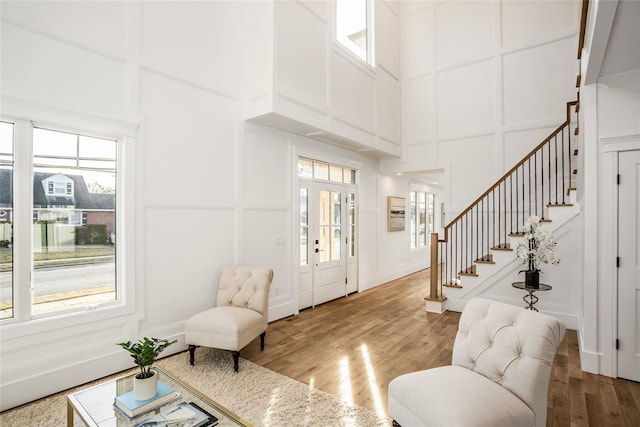 45 Mist Ln, Westbury, NY 11590 - living room with a decorative wall, a towering ceiling, light wood-style flooring, healthy amount of natural light, and stairs
