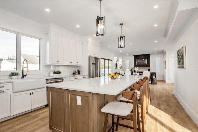 45 Mist Ln, Westbury, NY 11590 - kitchen featuring a sink, stainless steel appliances, white cabinetry, a large island, and recessed lighting