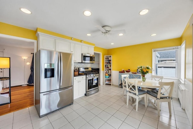 86 Woodbine Dr N, Hicksville, NY 11801 - kitchen featuring stainless steel appliances, white cabinetry, a ceiling fan, dark countertops, and backsplash