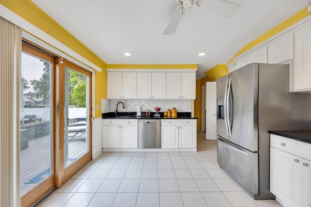 86 Woodbine Dr N, Hicksville, NY 11801 - kitchen featuring appliances with stainless steel finishes, dark countertops, decorative backsplash, ceiling fan, and white cabinetry