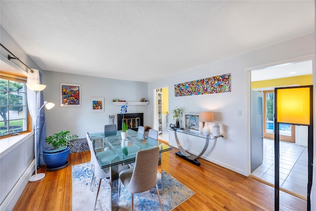 86 Woodbine Dr N, Hicksville, NY 11801 - dining space featuring a glass covered fireplace and light wood finished floors