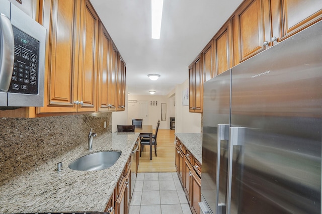 103-26 68th Ave Unit 2E, Forest Hills, NY 11375 - kitchen with stainless steel appliances, a sink, light tile patterned flooring, tasteful backsplash, and brown cabinetry
