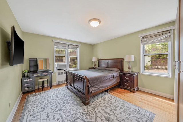 103-26 68th Ave Unit 2E, Forest Hills, NY 11375 - bedroom with radiator, wood finished floors, baseboards, and cooling unit