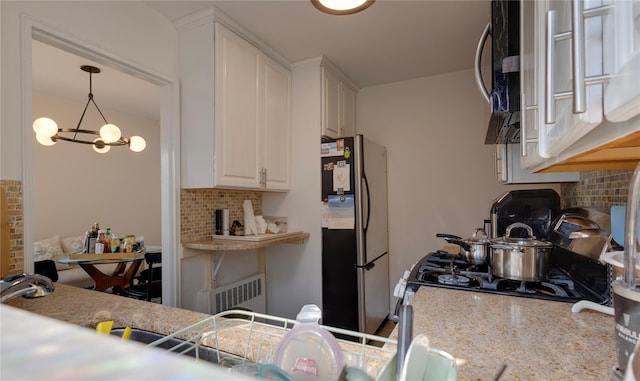 50 Brompton Unit 3K, Great Neck, NY 11021 - kitchen featuring freestanding refrigerator, tasteful backsplash, white cabinetry, and light stone counters