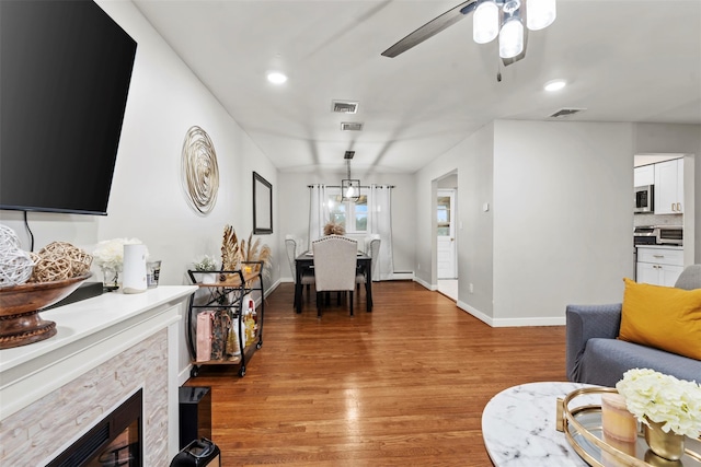 45 Maple Dr, Stony Point, NY 10980 - living room with light wood finished floors, baseboards, a ceiling fan, a stone fireplace, and recessed lighting