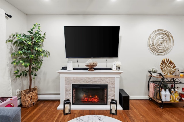 45 Maple Dr, Stony Point, NY 10980 - living area with wood finished floors, a baseboard heating unit, baseboards, and a warm lit fireplace