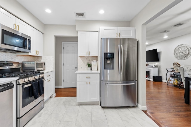 45 Maple Dr, Stony Point, NY 10980 - kitchen featuring stainless steel appliances, light countertops, white cabinets, backsplash, and recessed lighting