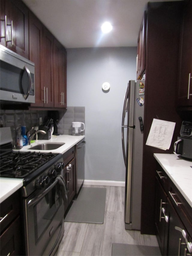 88-25 155th Unit 2M, Howard Beach, NY 11414 - kitchen with appliances with stainless steel finishes, a sink, tasteful backsplash, light countertops, and light wood-style floors