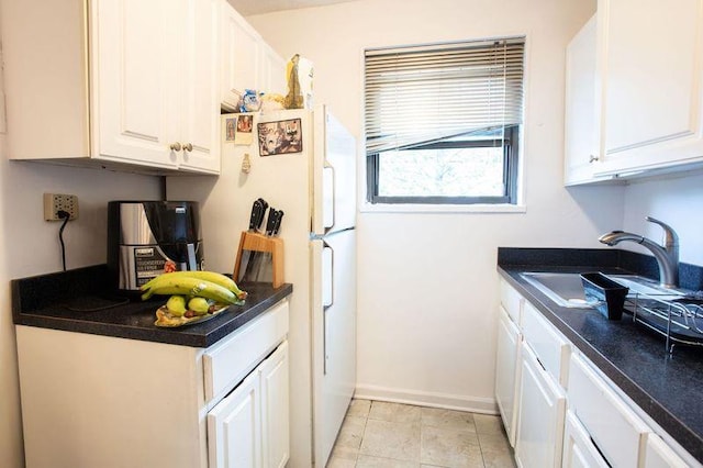 67-89 136th St Unit A, Kew Garden Hills, NY 11367 - kitchen featuring a sink, white cabinets, dark countertops, baseboards, and freestanding refrigerator