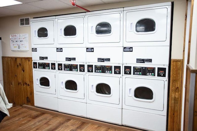 67-89 136th St Unit A, Kew Garden Hills, NY 11367 - communal laundry room featuring stacked washer / drying machine, washer and clothes dryer, wood finished floors, and wainscoting