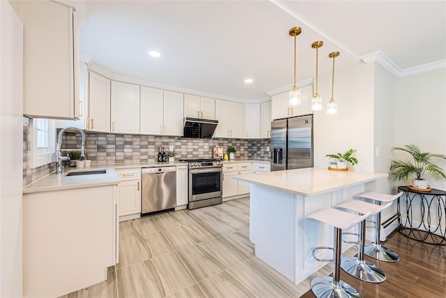 29 Underhill Ave, Syosset, NY 11791 - kitchen with stainless steel appliances, a sink, a breakfast bar area, ornamental molding, and light countertops