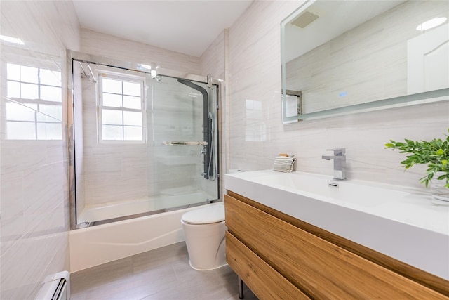29 Underhill Ave, Syosset, NY 11791 - full bath featuring tile walls, a baseboard radiator, vanity, bath / shower combo with glass door, and toilet